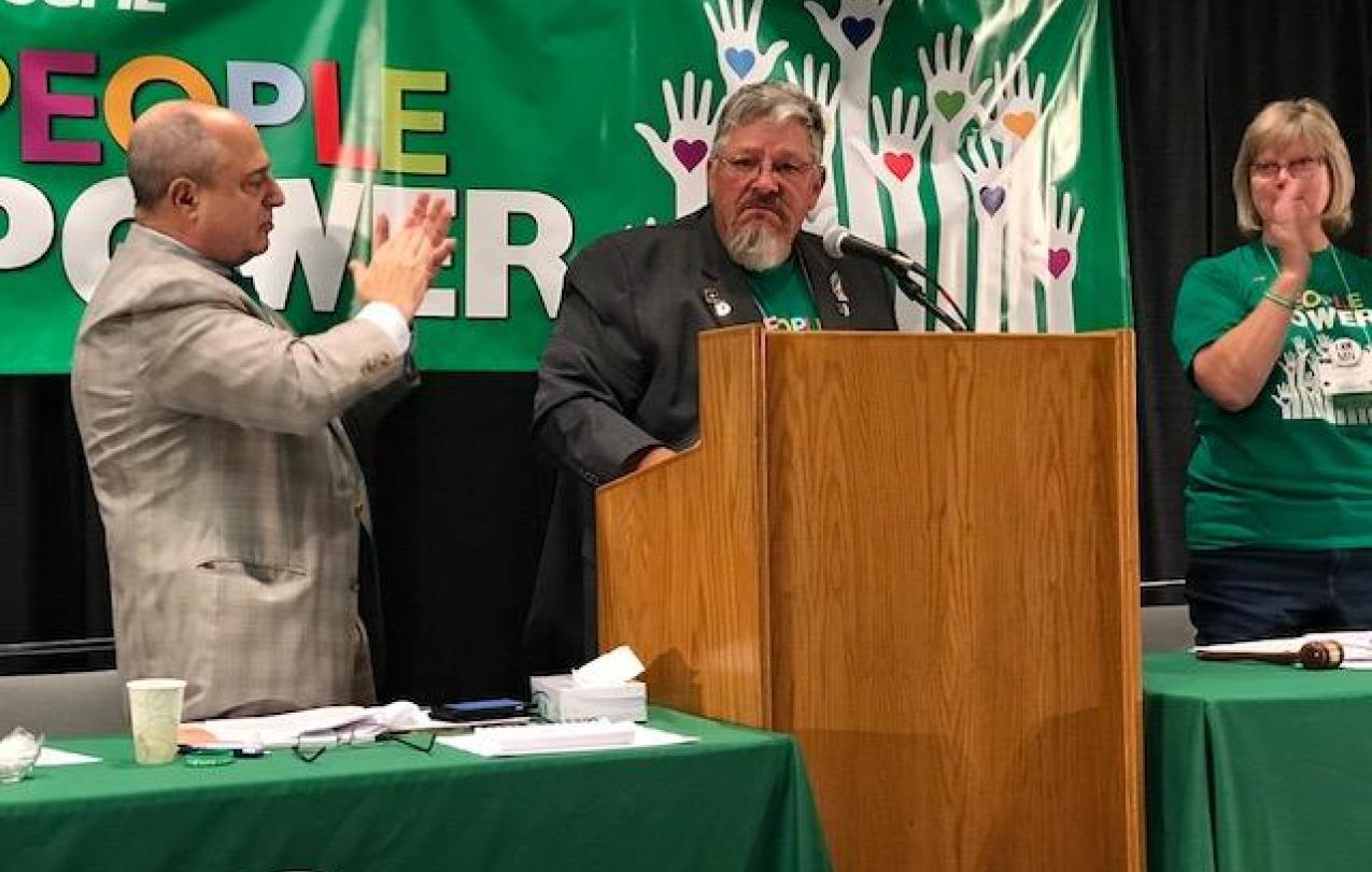 AFSCME Council 5 executive director Eliot Seide and president Judy Wahlberg applaud Council 61 president Danny Homan (center).